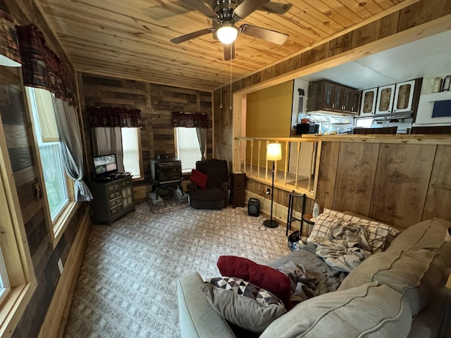 8210 N Johnson Rd, Irons, MI 49644 - carpeted living area with wood walls, wood ceiling, ceiling fan, and a wood stove