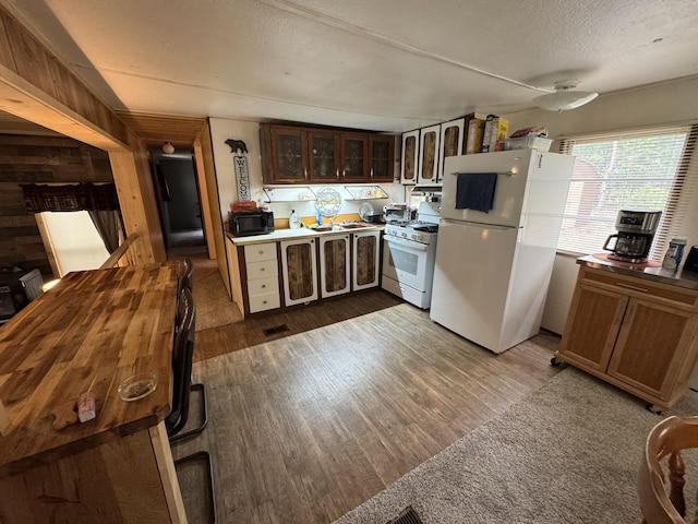 8210 N Johnson Rd, Irons, MI 49644 - kitchen with white appliances, dark wood finished floors, glass insert cabinets, and a textured ceiling