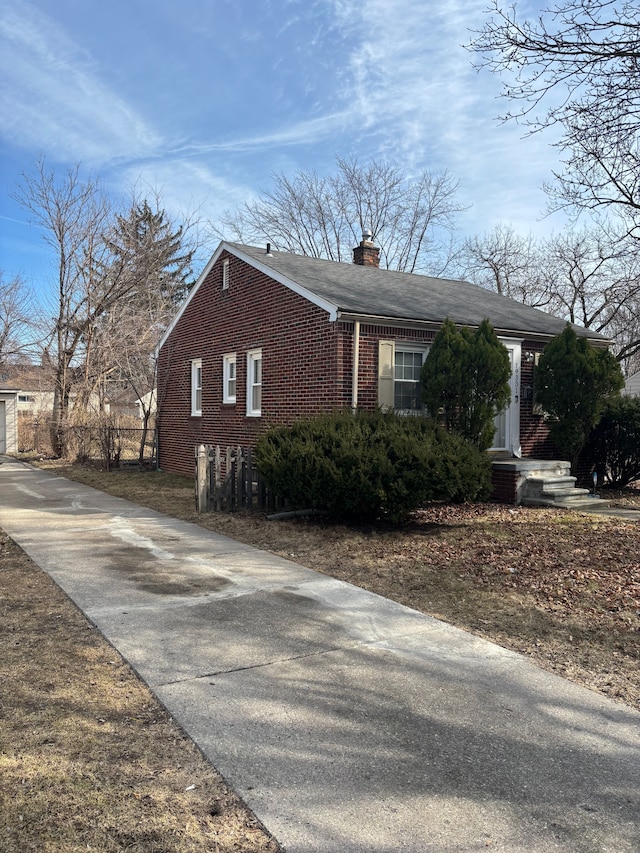 view of side of property with brick siding and a chimney