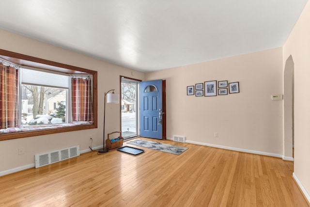 entryway with light wood-type flooring, visible vents, and baseboards