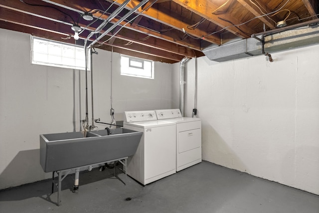 clothes washing area with laundry area, independent washer and dryer, and a sink