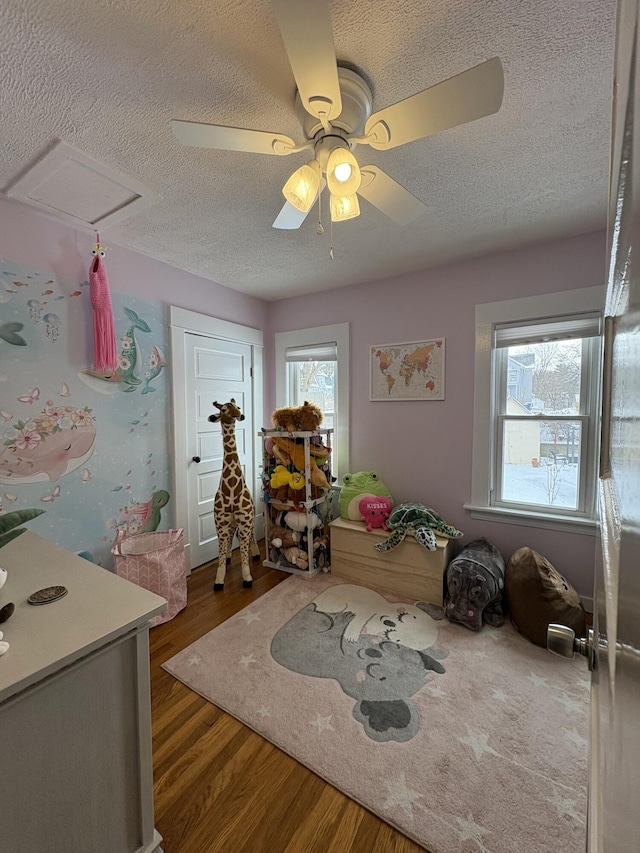 recreation room with hardwood / wood-style floors and a textured ceiling