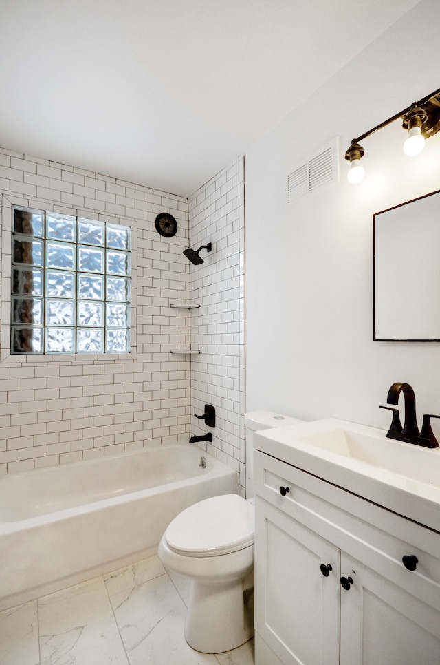 full bathroom with toilet, vanity, and tiled shower / bath