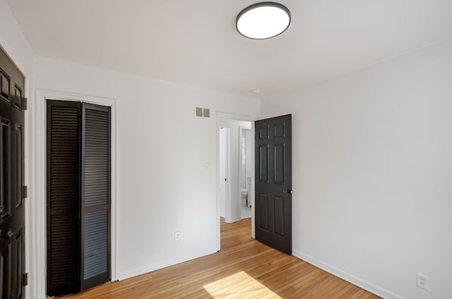 unfurnished bedroom featuring light hardwood / wood-style flooring and a closet