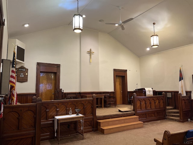 interior space featuring high vaulted ceiling, wood walls, ceiling fan, and carpet flooring