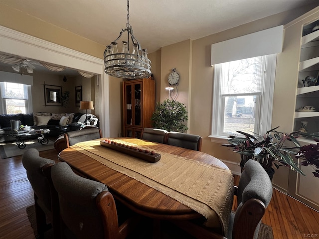 dining area with dark hardwood / wood-style floors and a chandelier