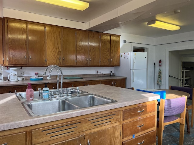 kitchen featuring white refrigerator and sink