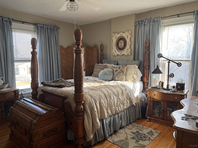 bedroom with ceiling fan, a textured ceiling, and light wood-type flooring