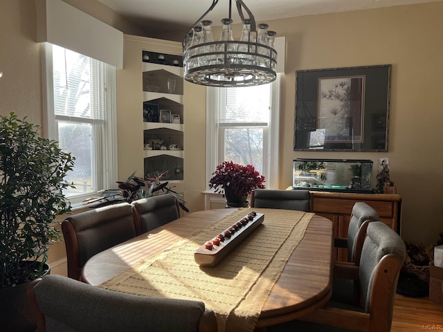 dining space with a notable chandelier, plenty of natural light, and hardwood / wood-style floors