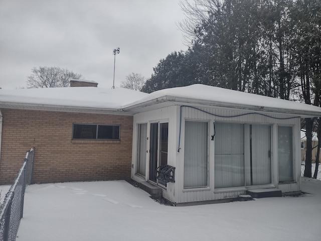 view of snow covered back of property