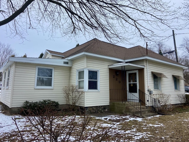 bungalow featuring roof with shingles