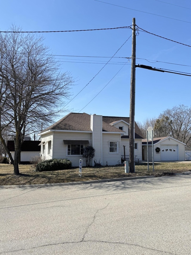 view of front of property featuring an outbuilding and a shingled roof