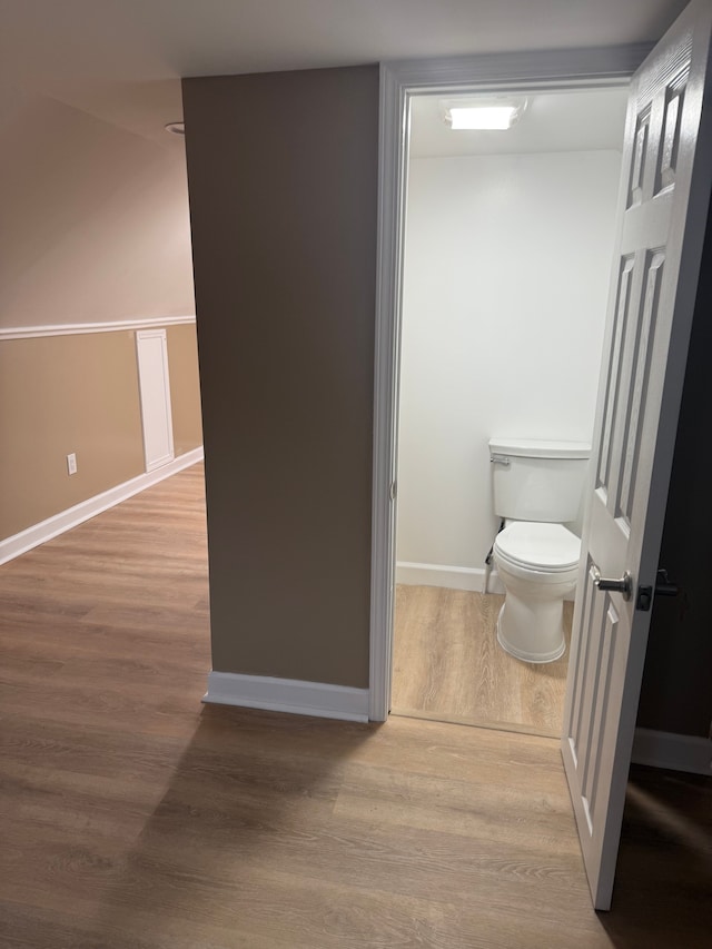 bathroom with baseboards, toilet, and wood finished floors