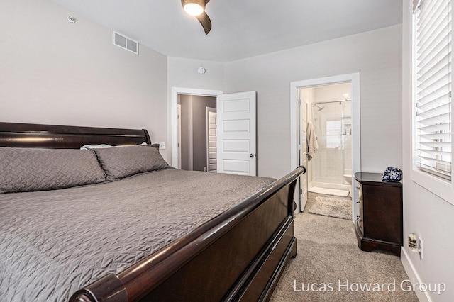 bedroom with connected bathroom, light colored carpet, and ceiling fan