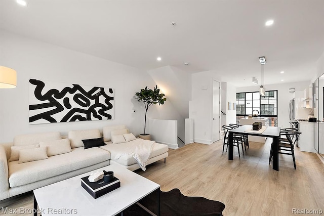 living area with recessed lighting and light wood-style floors