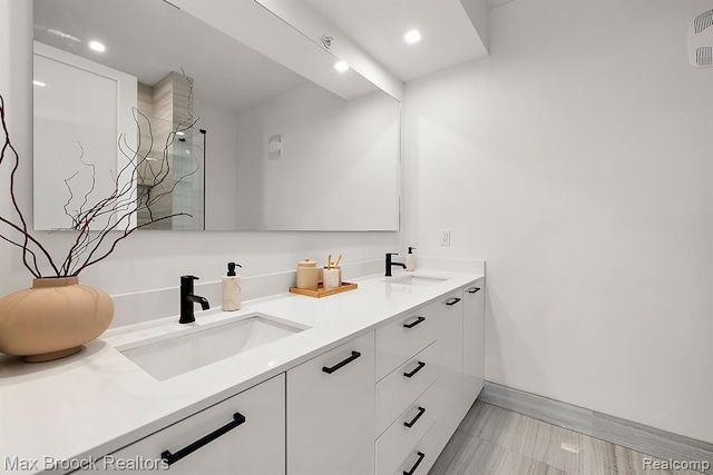 bathroom with a sink, a shower, recessed lighting, and double vanity