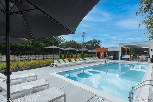 community pool featuring a patio area and fence