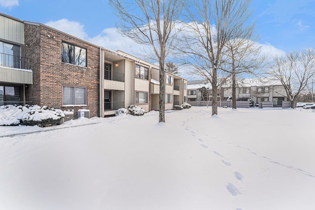 snow covered property featuring central AC