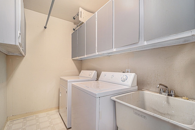 laundry room with light floors, cabinet space, separate washer and dryer, and a sink