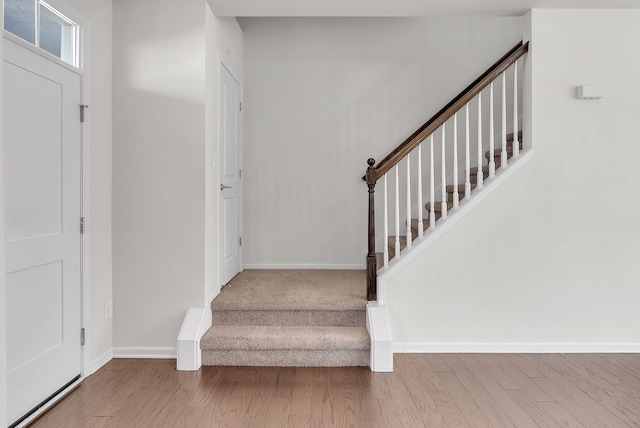 foyer featuring stairs, baseboards, and wood finished floors