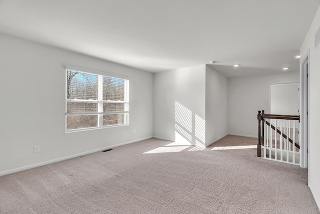 carpeted spare room with baseboards, visible vents, and recessed lighting