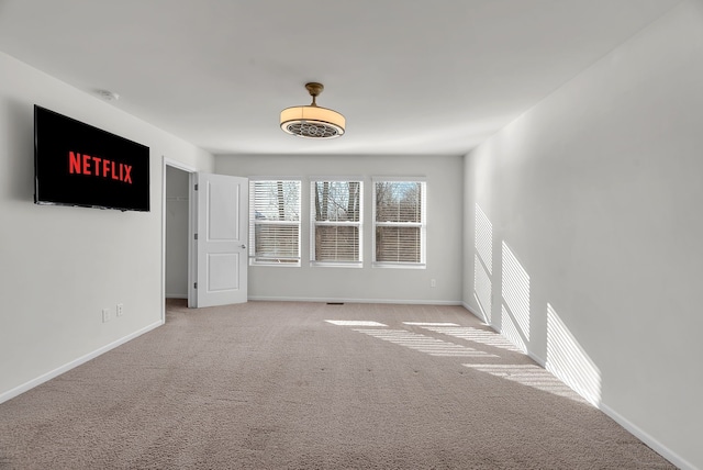 empty room featuring baseboards and carpet flooring