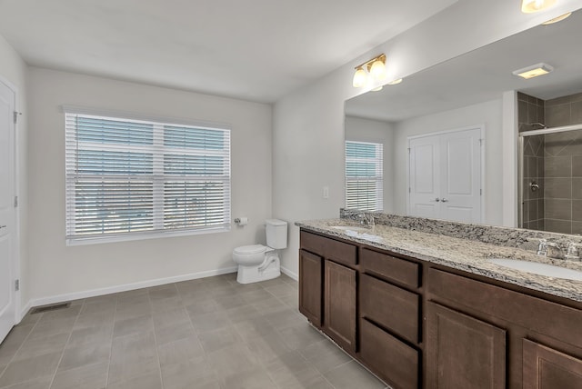 bathroom with baseboards, a sink, toilet, and a shower stall