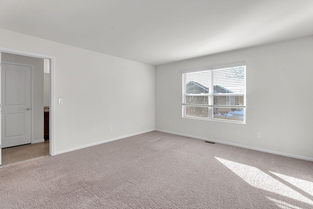 empty room with light carpet, visible vents, and baseboards