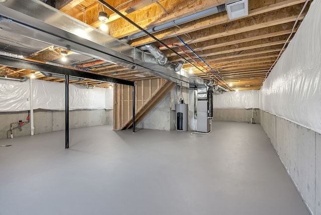 unfinished basement featuring heating unit, visible vents, and electric water heater