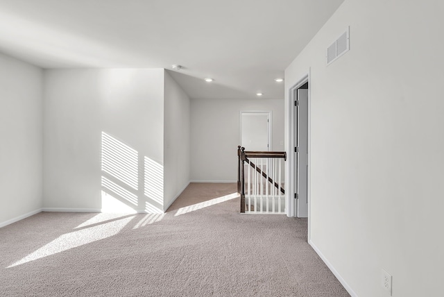 spare room featuring recessed lighting, carpet flooring, visible vents, and baseboards