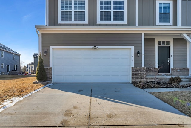 view of front facade with board and batten siding, concrete driveway, brick siding, and a garage