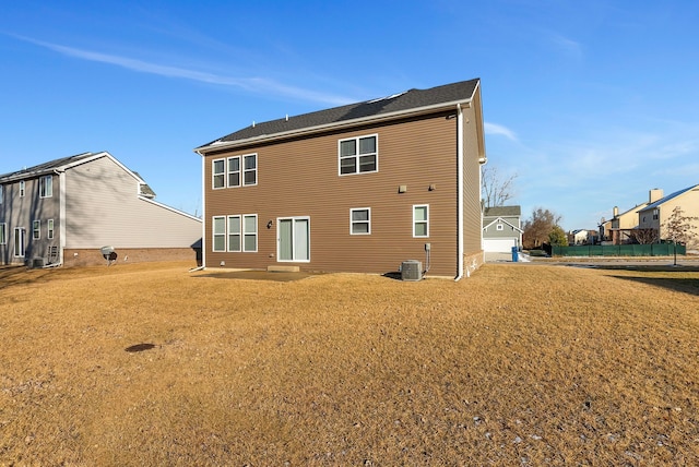 back of house with central AC and a yard