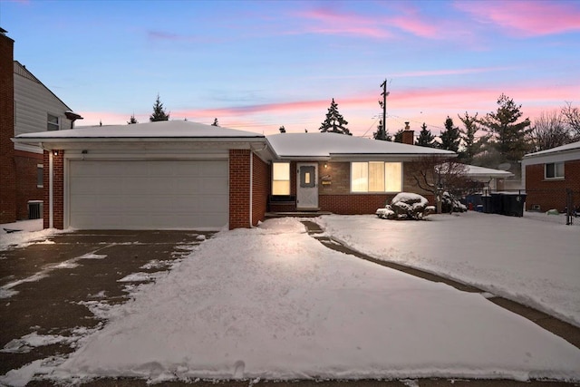 ranch-style home featuring a garage and central AC unit