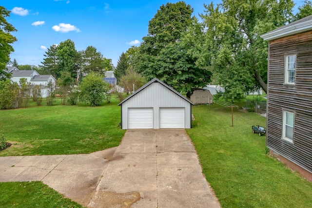 view of yard with a garage and an outbuilding