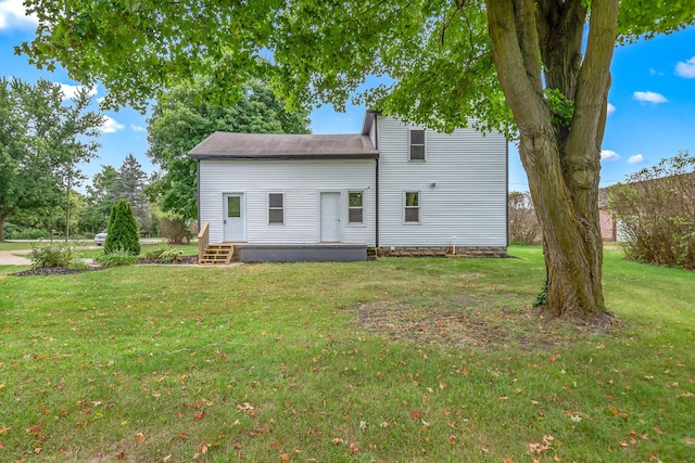 rear view of property with a lawn