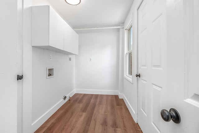 washroom featuring washer hookup, cabinets, and light wood-type flooring