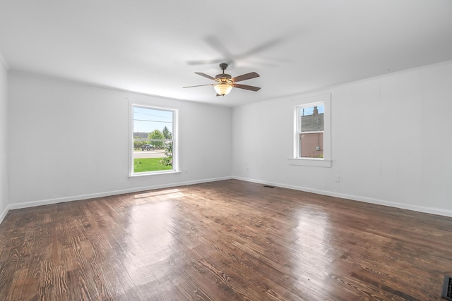 spare room featuring dark hardwood / wood-style flooring, ceiling fan, and a healthy amount of sunlight