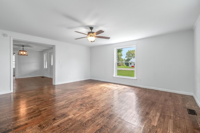 unfurnished room featuring ceiling fan with notable chandelier and dark hardwood / wood-style flooring