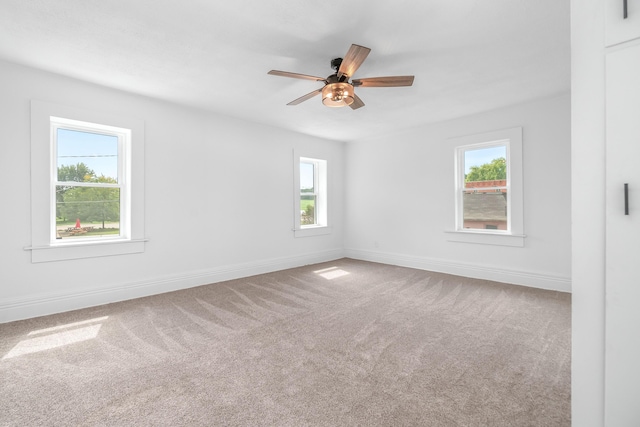 carpeted empty room with ceiling fan and a healthy amount of sunlight