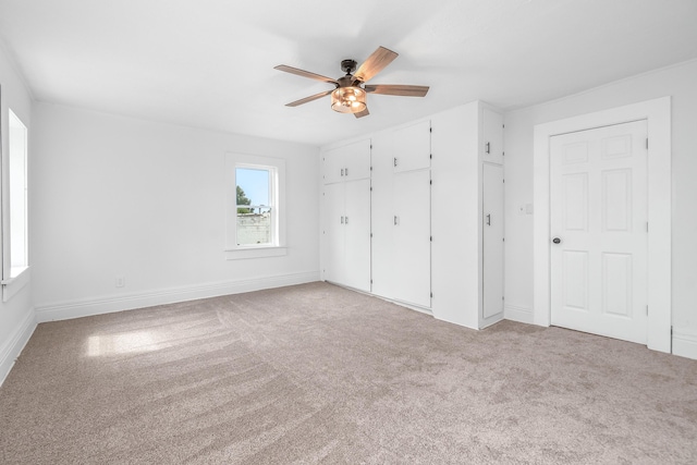 unfurnished bedroom with ceiling fan and light colored carpet