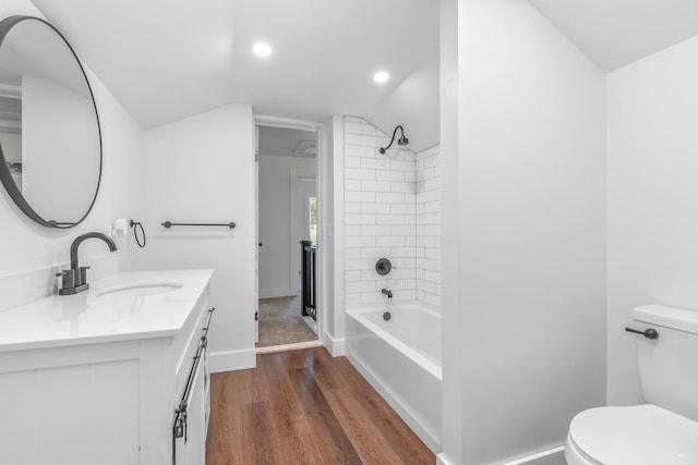 full bathroom with toilet, tub / shower combination, vaulted ceiling, vanity, and hardwood / wood-style flooring