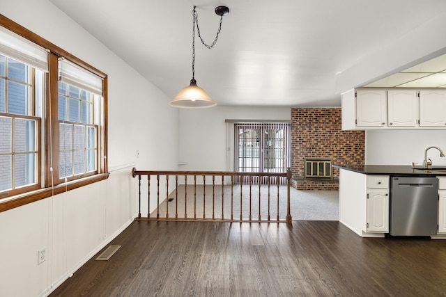 kitchen with white cabinets, hanging light fixtures, dishwasher, and sink