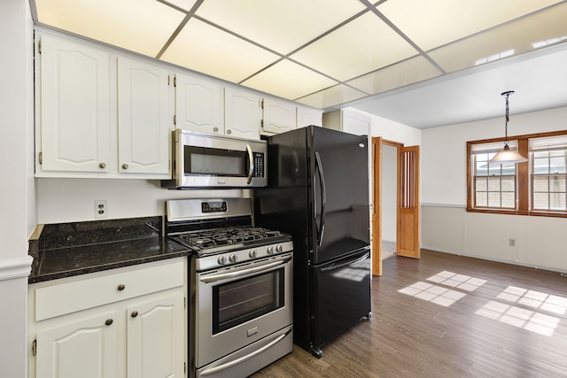 kitchen featuring white cabinetry, appliances with stainless steel finishes, hanging light fixtures, and dark hardwood / wood-style flooring