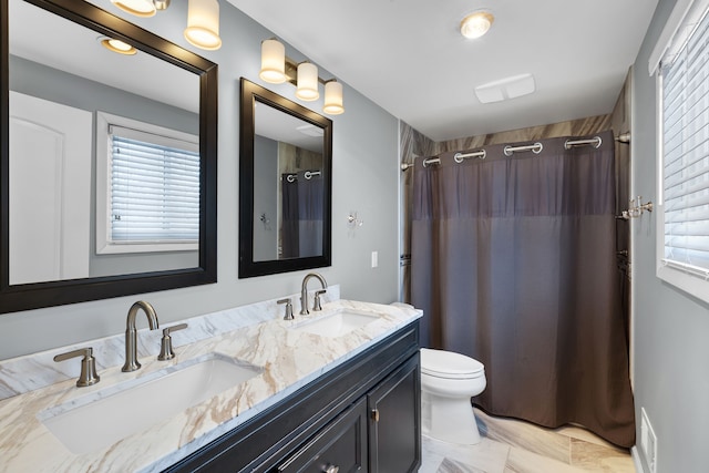 bathroom featuring toilet, vanity, and a shower with shower curtain