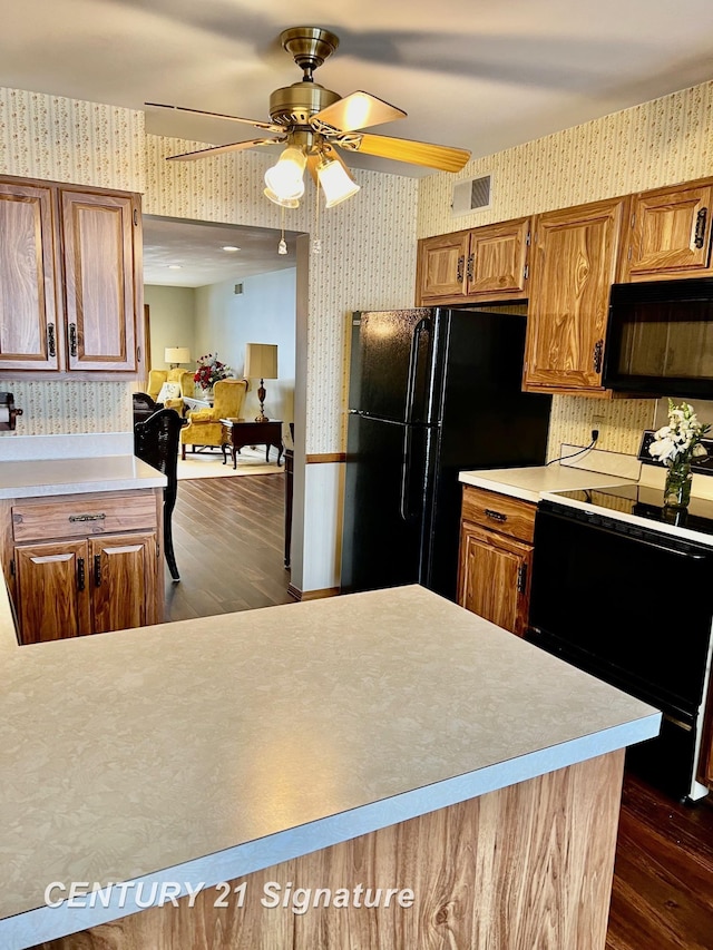 kitchen featuring dark wood-type flooring, ceiling fan, and black appliances