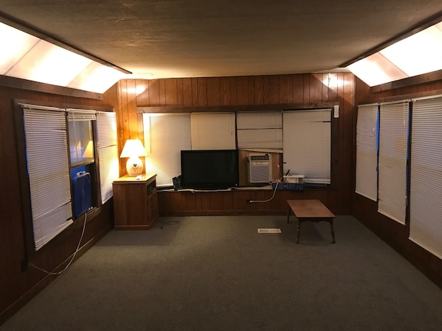 carpeted home office with cooling unit, vaulted ceiling, and wooden walls