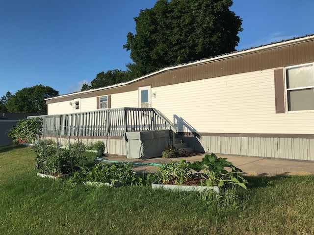 rear view of house featuring a deck and a yard