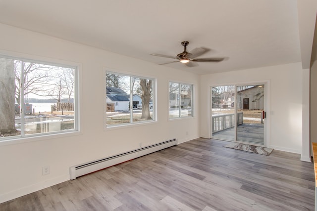 unfurnished sunroom featuring a baseboard radiator, a healthy amount of sunlight, and ceiling fan