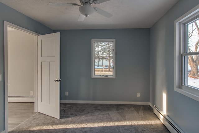 unfurnished bedroom with a baseboard heating unit, ceiling fan, a textured ceiling, and carpet