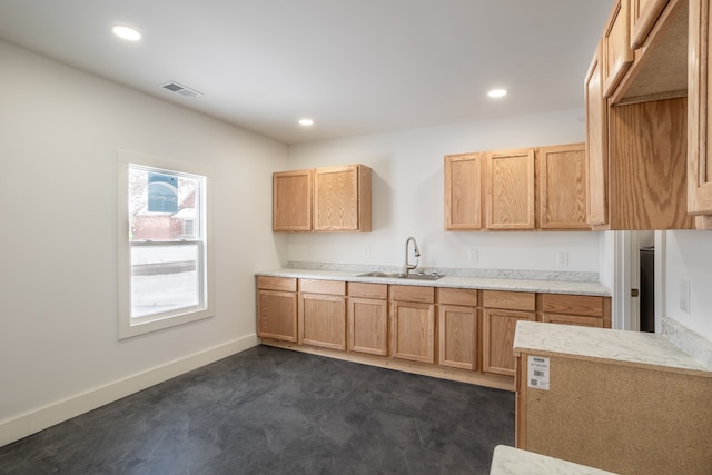 kitchen with light brown cabinetry and sink